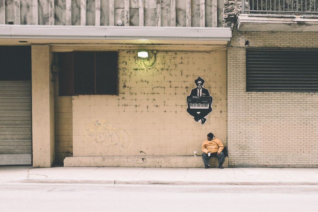 street photography man sitting on the pavement